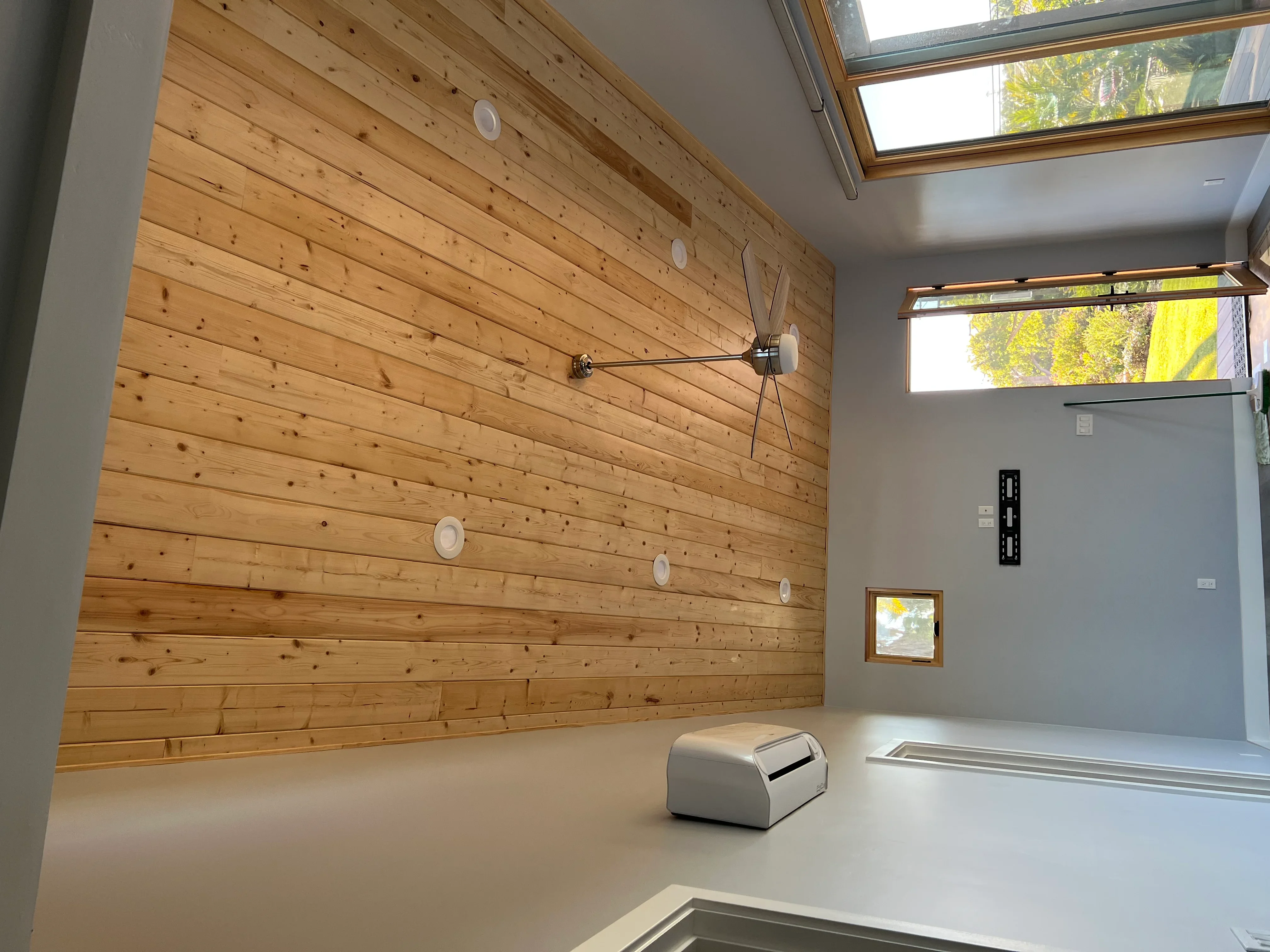 Knotty pine shiplap accent wall with recessed lighting and electrical outlets in modern interior